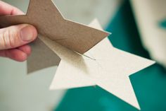 someone cutting out a paper star with scissors