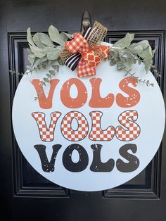 a sign that says volls vols with leaves and bows hanging on the front door