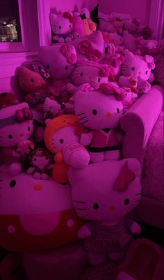 a pile of hello kitty stuffed animals sitting on top of a couch in a living room