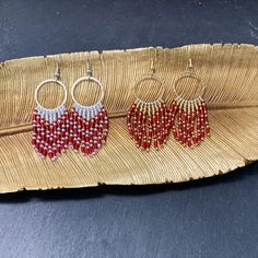 three pairs of beaded hoop earrings on a banana leaf with beads hanging from them