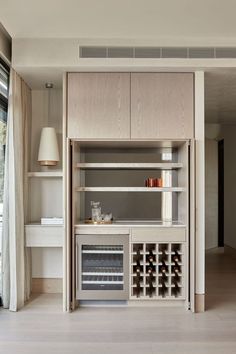 a kitchen with an oven and wine rack in the center, next to a window