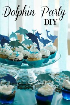 there are cupcakes that have dolphin decorations on top of them and the words dolphun party diy above them