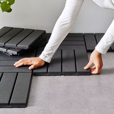 a person standing on top of a black mat with their hands on the floor next to it