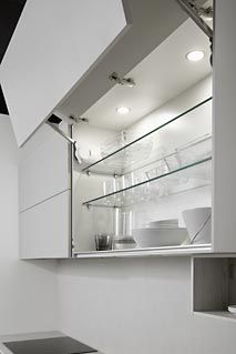 an empty kitchen with white cabinets and black counter tops, is seen in this image