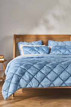 a bed with blue comforter and pillows in a room