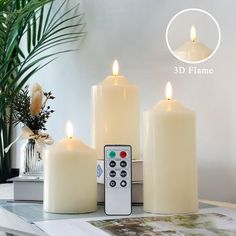 three white candles with remote controls sitting on a table