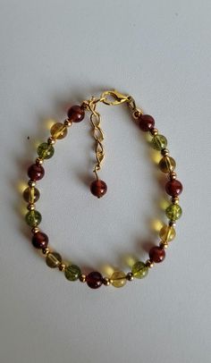 This Fall colored bracelet has 3 different gemstones with Gold-plated brass beads and findings. They are Carnelian, Citrine and Peridot. The bracelet has a 1" extension with a beaded drop and lobster claw clasp.  Custom orders are welcome! Ask about free sizing. Hand-strung Amber Bracelet Jewelry, Hand-strung Amber Bracelet, Gold Czech Glass Hand-strung Bracelet, Hand-strung Gold Jewelry With Czech Glass, Gold Hand-strung Czech Glass Bracelets, Hand-strung Gold Czech Glass Jewelry, Gold Czech Glass Jewelry, Hand-strung, Amber Czech Glass Round Beads Jewelry, Adjustable Amber Gemstone Bracelets