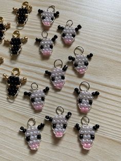 a bunch of small cow charms sitting on top of a wooden table