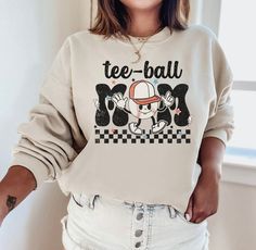 ⚾ Our proud Tee Ball Mom sweatshirt is the perfect way to show off your pride as a T-ball mama! This soft and comfy sweatshirt will become your go-to for those early morning games and practices. Show your support for your little player and get ready to cheer your heart out in this trendy t-ball mama sweater! ⚾ ♡ STYLE Say hello to your new favorite sweatshirt! Our sweatshirts are made with the highest quality materials and are super soft and cozy! Unisex Crewneck Sweatshirt - 50% cotton, 50% pol T Ball Mom Outfit, Sports Mom Shirt, T Ball Mom Shirts, Tball Mom Shirts, Tee Ball Mom Shirts, Baseball Fits, Tball Mom, Tee Ball Mom, Baseball Mom Outfits