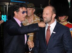 two men in suits and one is adjusting another man's tie at an event