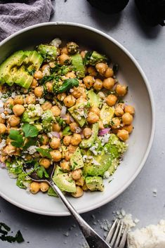 a white bowl filled with chickpeas, avocado and cilantro