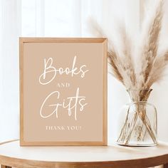 there is a sign that says books and gifts on it next to a vase with feathers