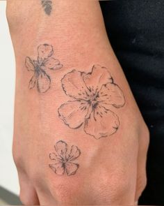 a woman's hand with three flowers on it