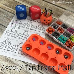 an orange tray filled with halloween themed beads next to some dices and pumpkins