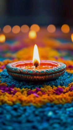 a lit candle sitting on top of a colorful rug