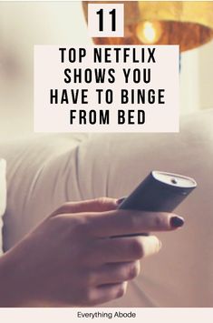 a person holding a cell phone with the text 11 top netflix shows you have to binge from bed