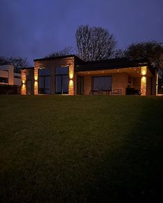 a house lit up at night with outdoor lighting