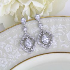 "Vintage style dangle earrings have the drama of 1920's platinum and diamond jewelry. At 1 3/4\" h x 3/4\" w, these beautiful bridal earrings are a must-have for the bride seeking a one-of-a-kind design for her wedding day! With silver pave scrolls and micro pave dangles, these CZ earrings have the elegance of genuine vintage heirlooms. Matching necklace; https://www.etsy.com/listing/261838550/art-deco-necklace-crystal-wedding" Classic Cubic Zirconia Chandelier Earrings For Wedding, Wedding Diamond Drop Earrings With Intricate Design, Intricate Design Diamond Drop Earrings For Wedding, Classic Silver Chandelier Earrings For Wedding, Classic Chandelier Earrings With Intricate Design For Anniversary, Wedding Earrings With Intricate Drop Design, Wedding Chandelier Earrings With Intricate Cubic Zirconia Design, Wedding Drop Earrings With Intricate Design, Intricate Drop Earrings For Wedding