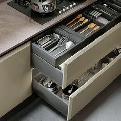 an open drawer in a kitchen with utensils and other cooking accessories inside it