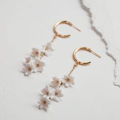 Classic gold hoop earrings accented with a cluster of hanging ivory florets. Dainty and whimsical, these romantic bridal earrings feature handmade polymer flowers. Assembled by hand in Los Angeles. Wedding Rose Gold Hoop Earrings 14k Gold Filled, Rose Gold 14k Gold-filled Hoop Earrings For Wedding, White 14k Gold Filled Bridal Earrings For Wedding, Delicate Hoop Earrings With Flower Charm, Delicate White Hoop Earrings With Ear Wire, White 14k Gold Filled Earrings For Weddings, Delicate White 14k Gold Filled Earrings, 14k Gold Filled White Bridal Earrings For Wedding, Wedding White 14k Gold Filled Hoop Earrings