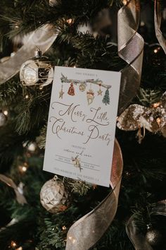 a merry little christmas party sign hanging from a tree with ribbon and ornaments around it