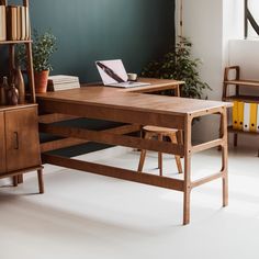 a wooden desk sitting in front of a book shelf with books on top of it