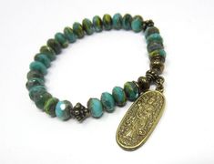 This bead bracelet features an intricately-carved brass charm pendant of Quan Yin, the Buddhist deity known as the Bodhisattva/Goddess of Mercy and Compassion.  Quan Yin is a divinely feminine being, providing comfort in times of stress and chaos and helping to foster love and compassion in oneself and in others.  She is a female version of the Avalokiteshvara Bodhisattva who works selflessly to relieve all sentient beings from suffering.  The beads are Czech Glass, in vibrant shades of green, w Handmade Spiritual Bronze Beaded Bracelets, Spiritual Handmade Bronze Beaded Bracelets, Handmade Spiritual Brass Beaded Bracelets, Spiritual Brass Beaded Bracelets, Spiritual Beaded Brass Bracelets, Spiritual Bronze Nickel-free Bracelets, Nickel-free Bronze Spiritual Bracelets, Bohemian Rosary Bracelet For Meditation, Divinely Feminine