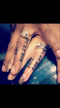 two people holding hands with tattoos on their fingers