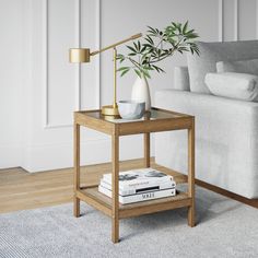 a living room with a couch, table and lamp on the floor next to it