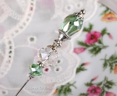 a close up of a green crystal beaded pin