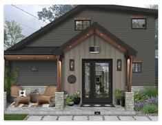 the front view of a house with two chairs on the porch and an entry door