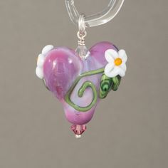 Heart pendant with flowers and vines. Beaded with sterling silver and swarovski crystals. All my beads are properly cleaned They are annealed in a digitally controlled kiln for strength and durability. Each bead is unique Please remember: although every effort is made to create a strong, stable bead, glass is still glass and should be handled with care. The item on the photo is the item sold. I never use stock images or same image for multiple items. We make every effort to provide high quality images to assist you in choosing your item. However, images may vary in color depending on your monitor color settings. If exact color is critical to your order we recommend contacting me by e-mail so I can help you. Thank you for looking at my work Madeleine Ahlström. Heart Shaped Spacer Beads Jewelry For Gifts, Whimsical Silver Jewelry With Heart Beads, Heart-shaped Sterling Silver Beaded Jewelry, Unique Pendant Jewelry With Spacer Beads, Sterling Silver Beaded Heart Jewelry, Sterling Silver Heart-shaped Beaded Jewelry, Silver Flower Jewelry With Spacer Beads, Handmade Whimsical Flower Pendant Jewelry, Gift Jewelry With Flower Charm And Czech Glass