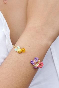 Introducing the Lemon And Flower Bangle Bracelet from Les Nereides' Summer Scents collection. This elegant piece showcases the vibrant flowers of Provence, with a stunning hand-enamelled lemon and a braided bangle. Made with high-quality materials including hand-enamelled gold-plated brass and faceted crystals, this bracelet is both simple and sophisticated. With a length of 5cm, width of 5.4cm, and weighing 8.87g, it is the perfect accessory to add a touch of luxury to any outfit. Shop now and elevate your style with Les Nereides. Summer Scents, Les Nereides, Summer Scent, Outfit Shop, Vibrant Flowers, French Designer, Vibrant Flower, Faceted Crystal, French Design