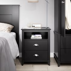 a black night stand next to a bed