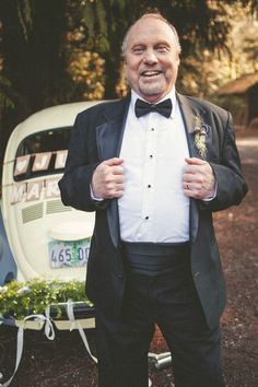 a man in a tuxedo standing next to a trailer