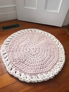 a crocheted rug on the floor in front of a door