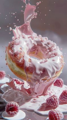 a donut with icing and raspberries falling into the water