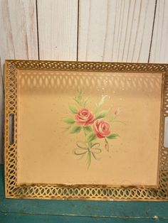 an old metal tray with flowers painted on it