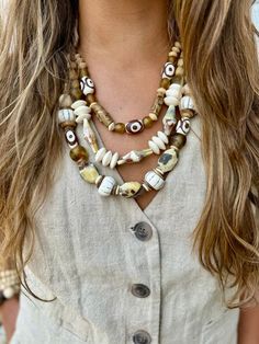 a woman wearing a necklace with shells on it