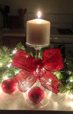 a lit candle sitting on top of a table next to christmas decorations and baubles