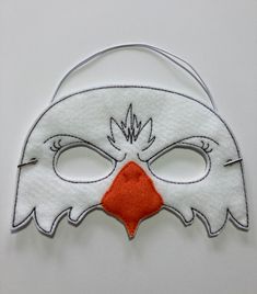 a white mask with a red nose and orange nose patch on the front of it