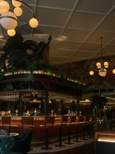 the interior of a restaurant with lights hanging from the ceiling and chandeliers on the ceiling