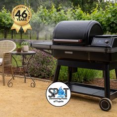 a bbq grill sitting on top of a patio next to a table and chairs