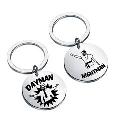 two metal key chains with the words dayman and michigan on them, one has an image of a man doing karate