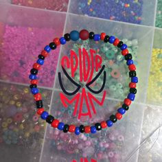 the beaded bracelet is decorated with red, white and blue beads that spell out spiderman