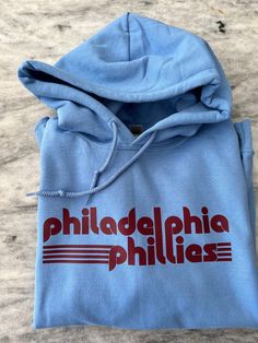 This Phillies crew comes in several color ways! Available in crew or hood. Throwback Team-colored Hoodie For Game Day, Throwback Team-colored Hoodie For Fan Gear, Sporty Crew Hoodie For Spring, Game Day Cotton Hoodie With Team Logo, Throwback Sweatshirt With Team Logo For Game Day, Game Day Throwback Hooded Sweatshirt, Cotton Hoodie With Team Logo For Game Day, Throwback Team-colored Sweatshirt For Fan Gear, Team-colored Throwback Sweatshirt For Fan Gear