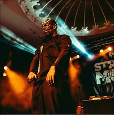 a man standing on top of a stage next to microphones in front of him