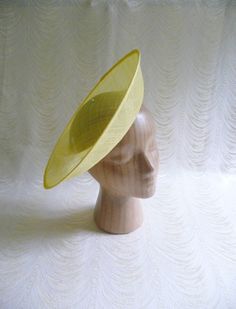 One contoured saucer with an upturned brim hat sinamay straw fascinator / hat base in yellow that measures approximately 12" (30.5 cm) in diameter. The base is contoured to fit against the head. The edges of the brim are finished in sinamay. The multi-layer stiffened sinamay straw has a great sturdy weave and provides excellent support for your millinery creations. This is NOT a ready to wear finished hat and it will not stay on your head unless you add a head band to wear. Add embellishments of your choice. ASinamay is a natural material and you may see some color striations in the weave. This is not a defect, but is the result of how different natural fibers respond to dye.  nice high quality base - I know you'll be pleased! This hat base is listed separately in fuchsia pink, white, cora Spring Adjustable Sinamay Fascinator, Fitted Sinamay Brimmed Top Hat, Fitted Fedora Fascinator For Summer, Spring Sinamay Fascinator, Spring Sinamay Fascinator Hat, Sinamay Fascinator Hat For Spring, Spring Church Sinamay Fascinator, Spring Fascinator With Sinamay And Curved Brim, Spring Church Fascinator In Sinamay