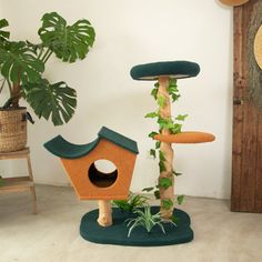 a cat tree with a bird house on top and a plant growing out of it