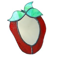 a red and green stained glass mirror with leaves on it's side, against a white background